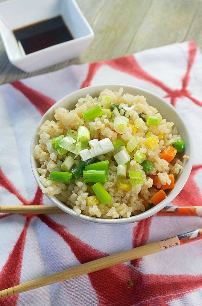 Bowl with fried rice, soy sauce, and chopsticks