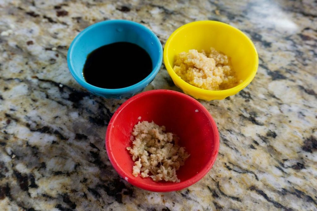 Bowls of soy sauce, garlic, and fresh ginger for the rice recipe