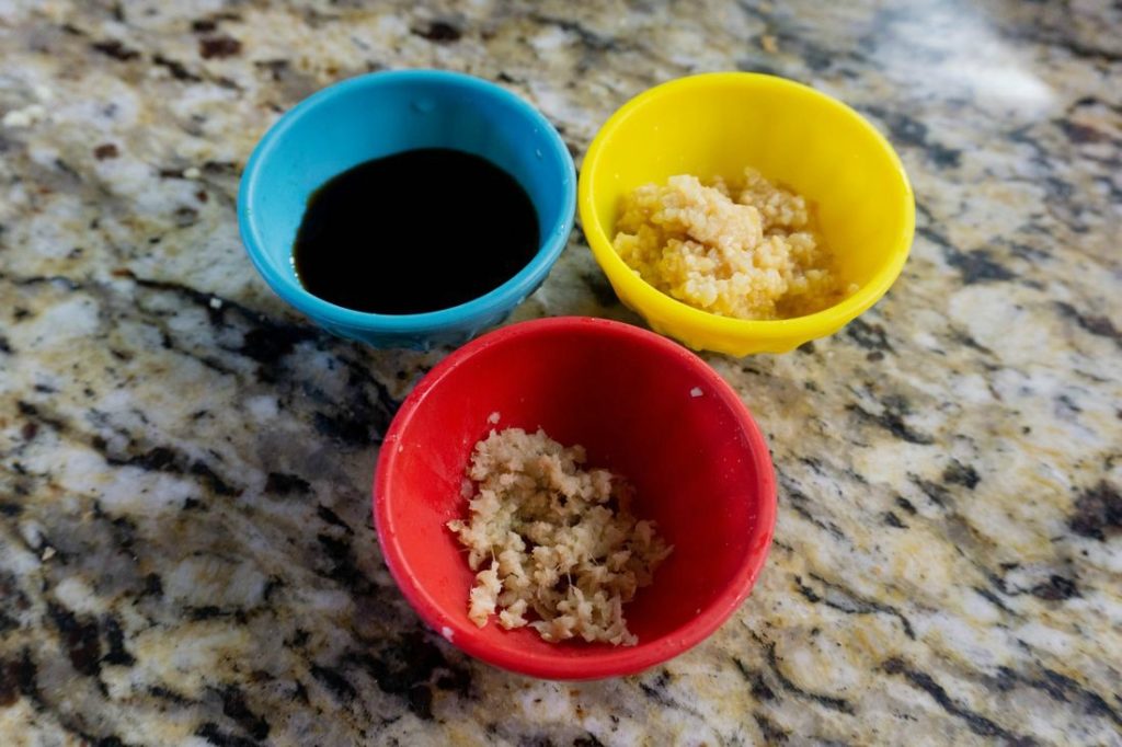 Bowls of soy sauce, garlic, and fresh ginger for the rice recipe 