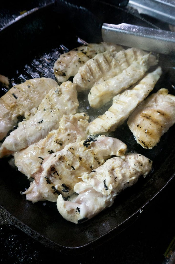 Chicken cooking in cast iron skillet